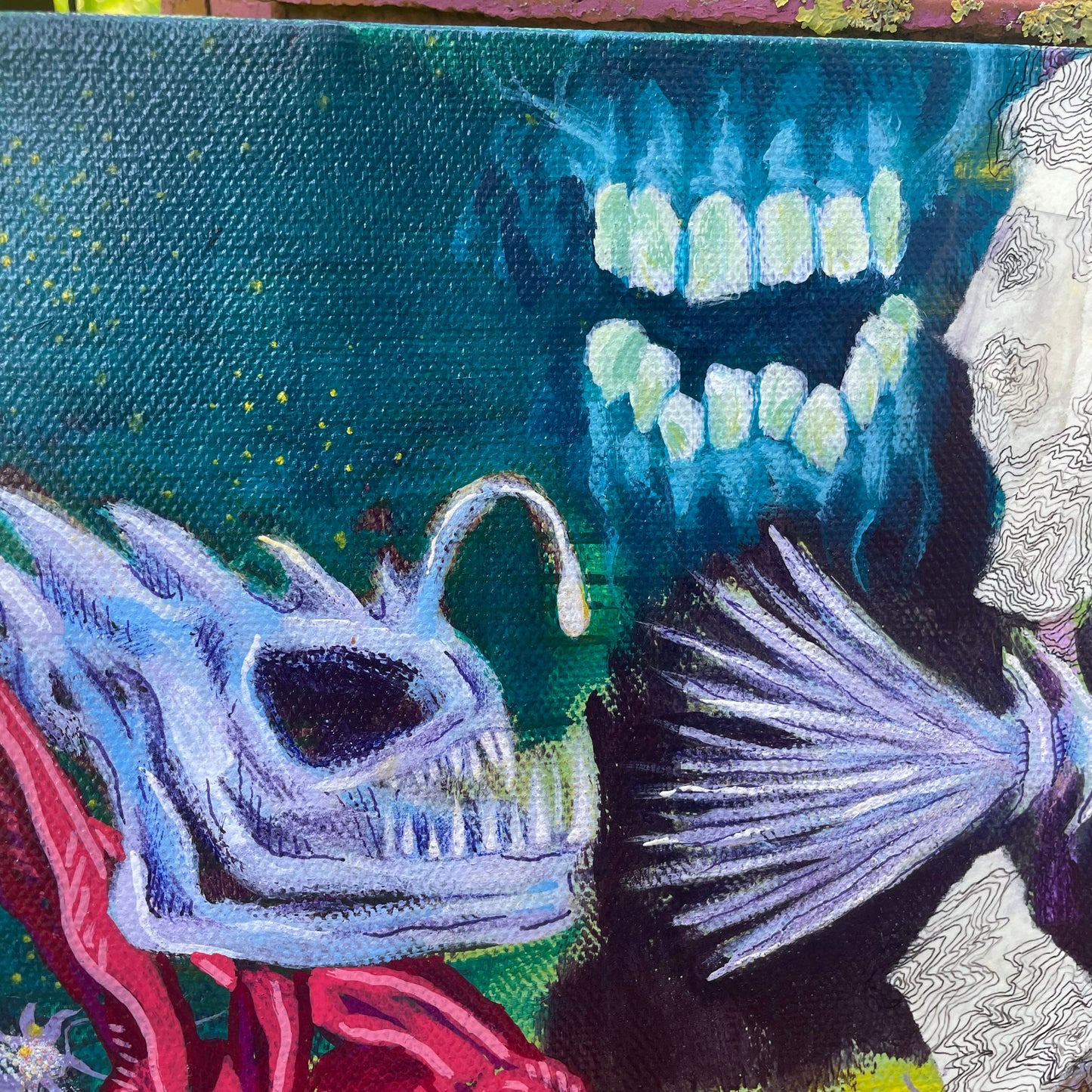 Close-up of fish skull, fish head and
teeth and gums in mixed media artwork.