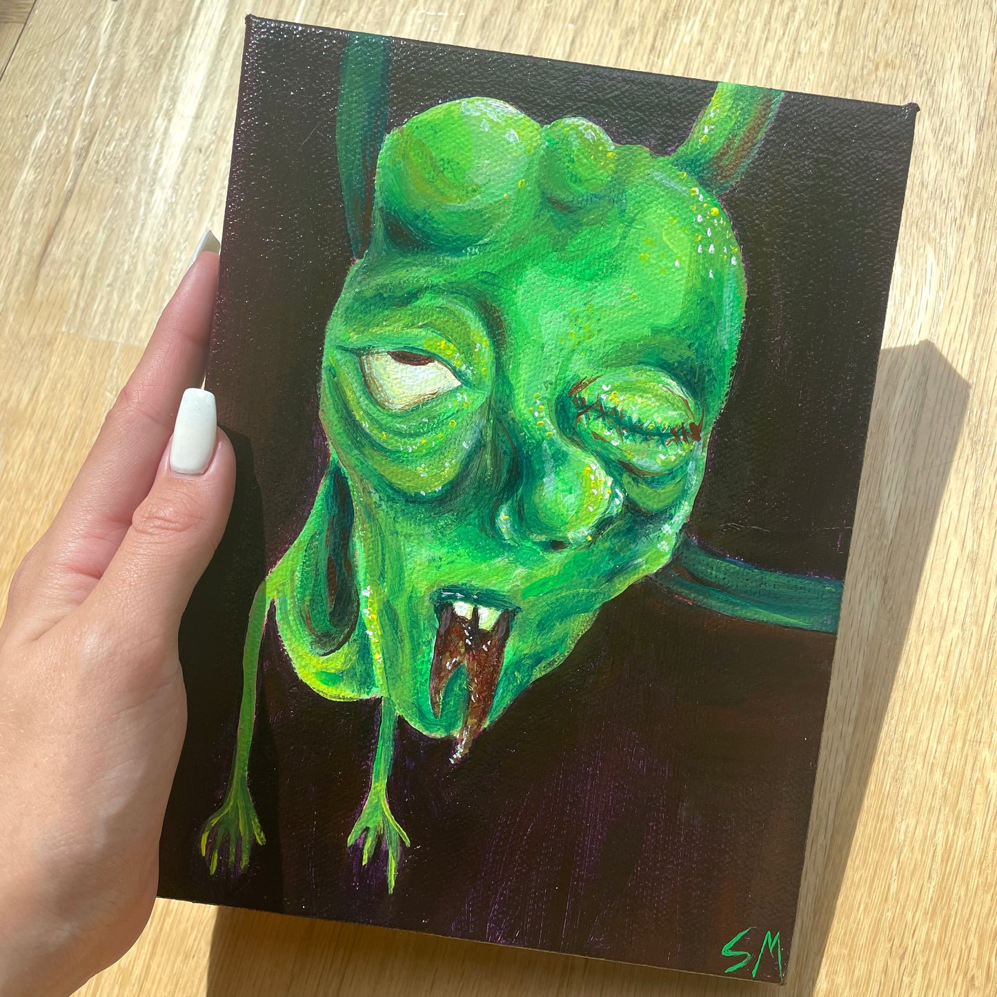 An original acrylic painting of a green monster dude by T00thFaerie Art on a 6” by 8” canvas. Painting features a green monster alien hanging down from above. The background is a very dark purple with some hints of brown as well.