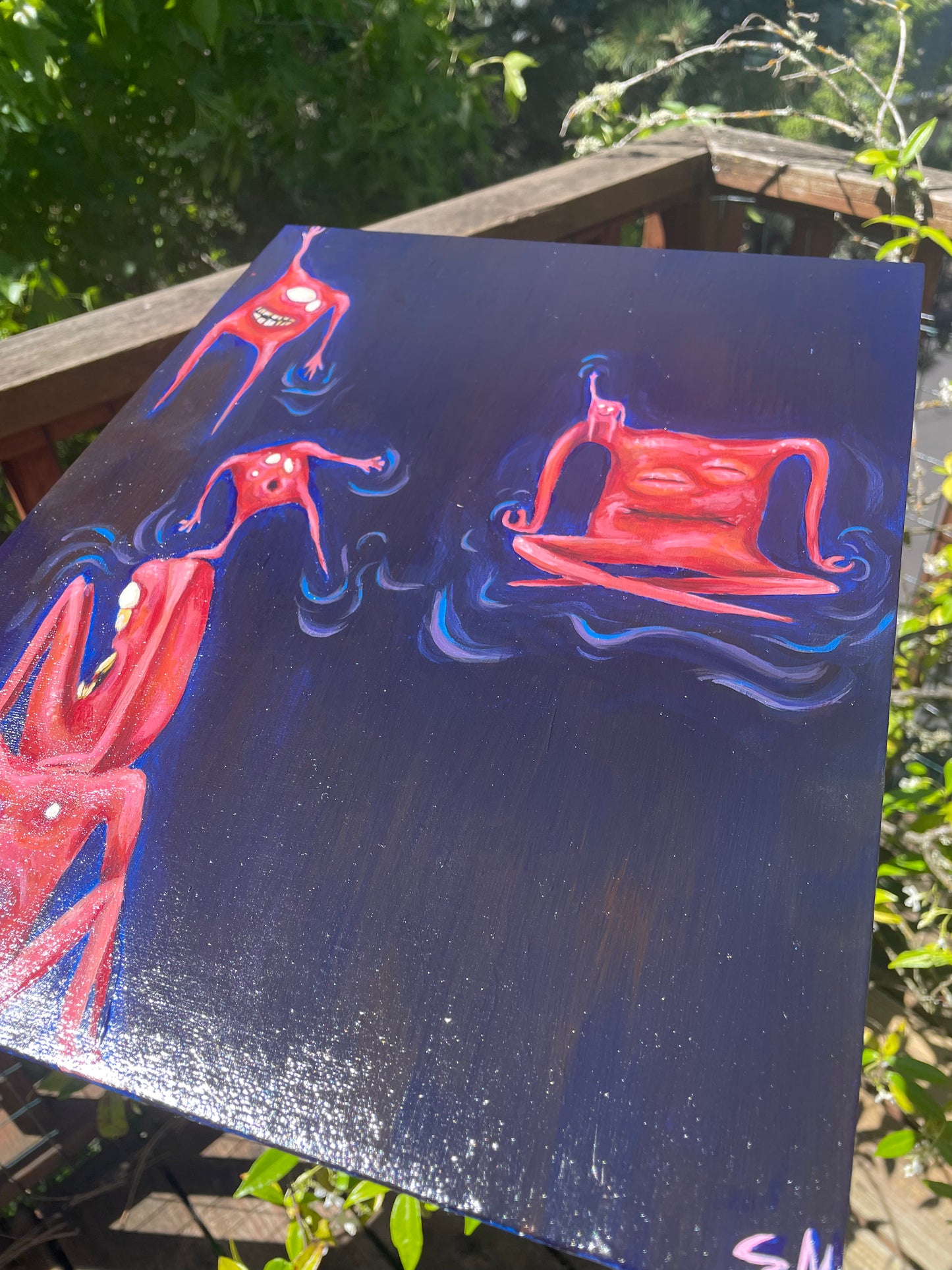 Close up, angled photo of a whimsical acrylic painting in front of plants. Painting is of six pinky orange square-shaped monsters/critters/creatures sitting, meditating, hanging, and balancing in space.