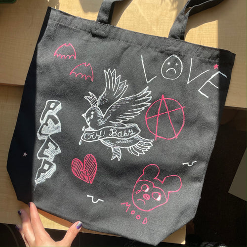 One-of-a-kind hand-painted Lil Peep-themed tote bag with hand-painted Lil Peep artwork! This tote bag is roughly 15” by 16” with a nice rectangular bottom - great as a reusable grocery bag, book bag, overnight bag - whatever. I used 3D fabric paint, so the design is textured and it is washable! 